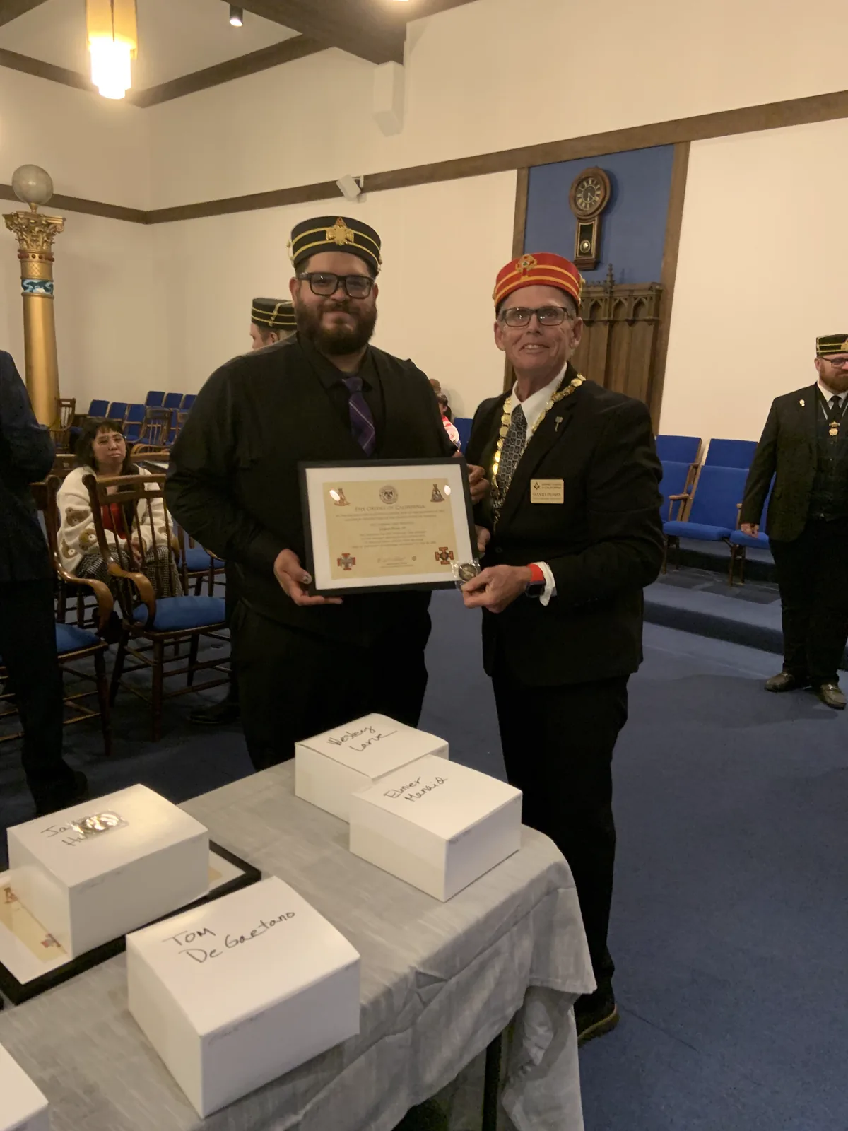 An officer presenting a certificate and coin to a new member