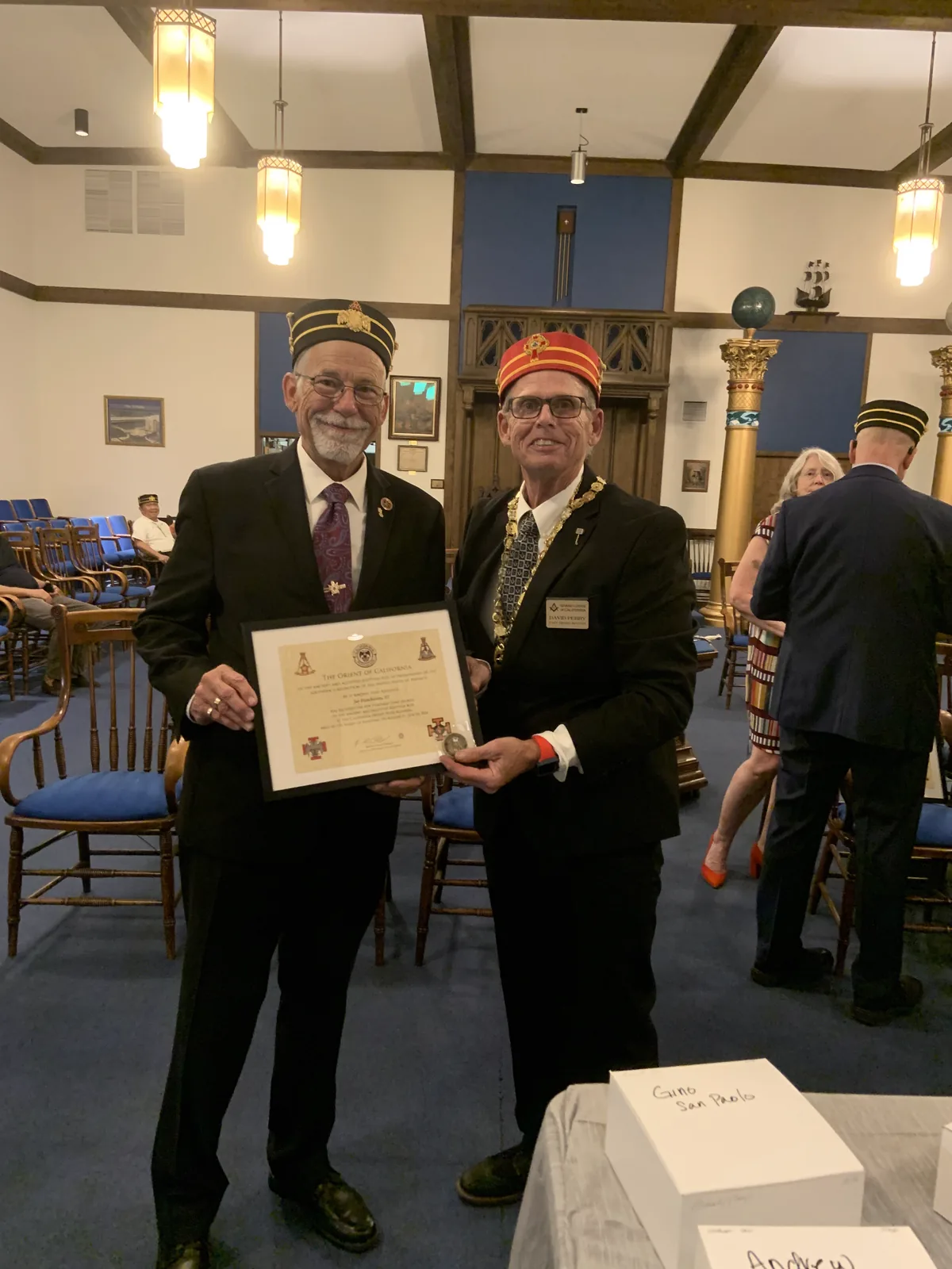 An officer presenting a certificate and coin to a new member