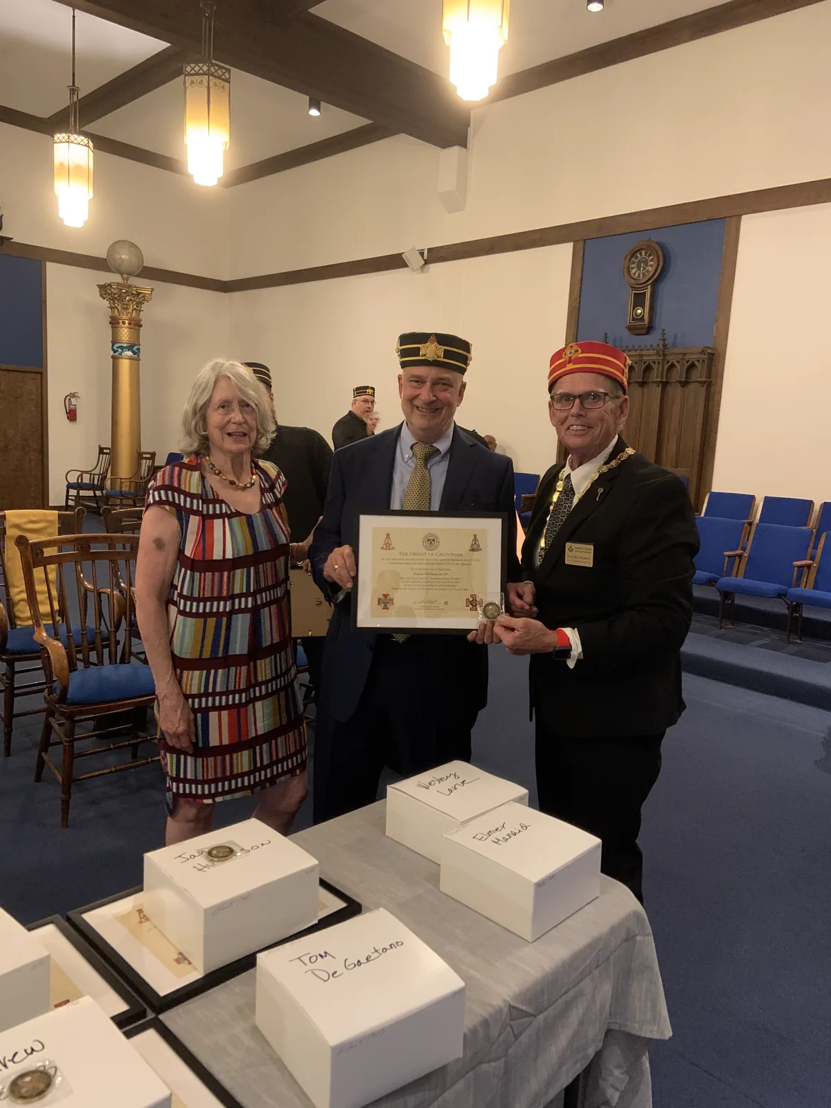 A new member's certificate presented as his wife looks on